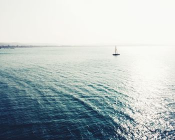 Sailboat sailing in sea against clear sky