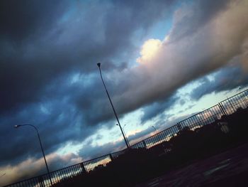 Low angle view of street light against cloudy sky