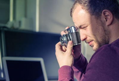 Young man photographing with digital camera