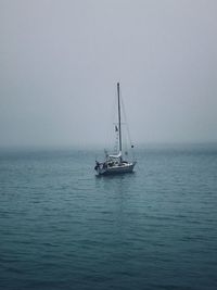 Sailboat sailing on sea against sky