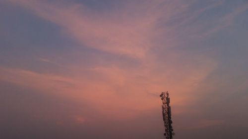 Low angle view of telephone pole against sky during sunset