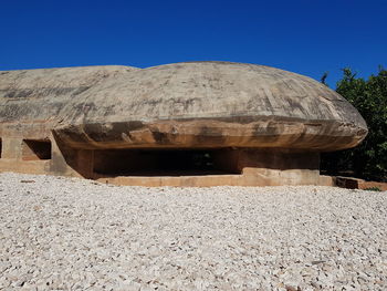 Built structure on rocks against clear blue sky