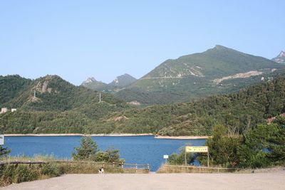 Scenic view of lake and mountains against clear sky