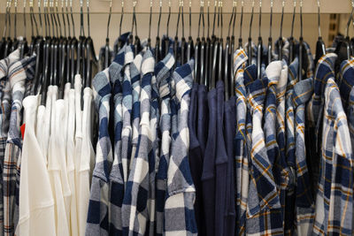 Men's cloth hanging on hangers in a store