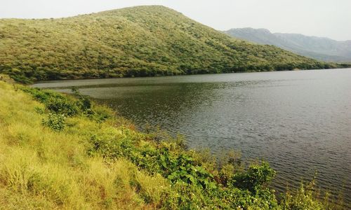 Scenic view of lake by mountains against sky