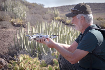 Senior man using drone on land