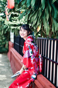 Portrait of smiling young woman sitting outdoors