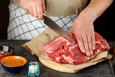 Midsection of man preparing food on cutting board