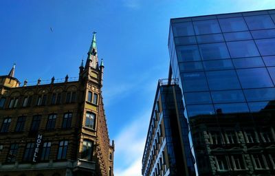 Low angle view of modern building against blue sky