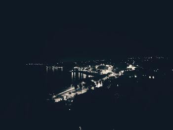 Illuminated cityscape against clear sky at night