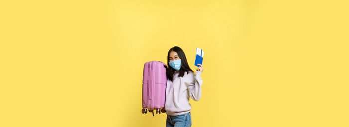 Low section of woman standing against yellow background