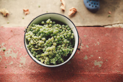 High angle view of grapes in bowl on retaining wall