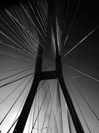 Low angle view of suspension bridge against sky