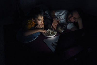 Rear view of two women sitting in the dark