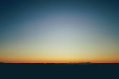 Scenic view of silhouette landscape against clear sky during sunset