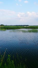 Scenic view of lake against cloudy sky