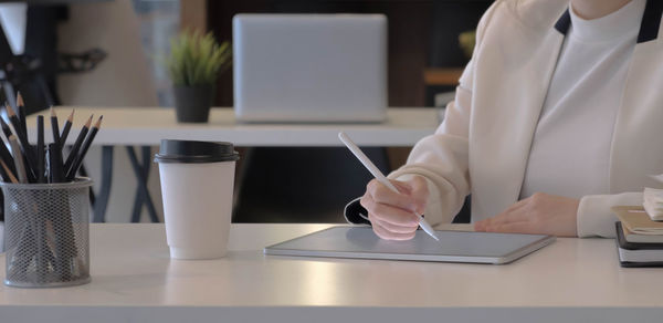 Midsection of man using laptop on table