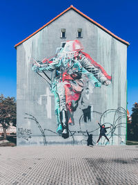 Graffiti on building against blue sky