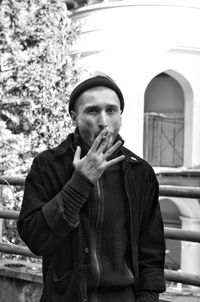 Portrait of man smoking cigarette in city