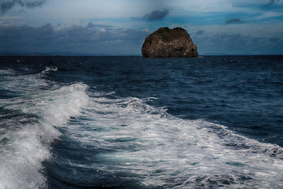 Rock formation in sea against sky