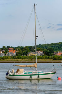 Boats moored on river against sky