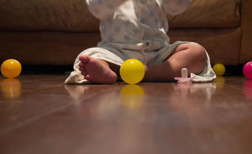 Low section of boy playing with ball at home