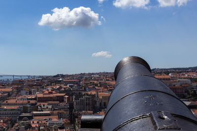 Close-up of canon with city in background