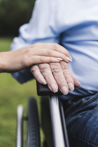 Young woman touching senior man's hand, close-up