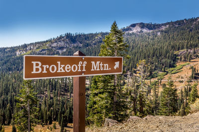 Information sign on landscape against mountain range