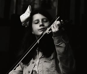 Portrait of young woman playing guitar