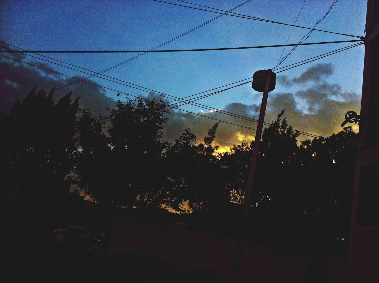 sky, silhouette, street light, power line, tree, sunset, lighting equipment, electricity, low angle view, dusk, electricity pylon, illuminated, power supply, cloud - sky, cable, nature, built structure, no people, cloud, outdoors