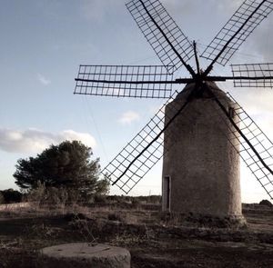 Low angle view of wind turbines on landscape