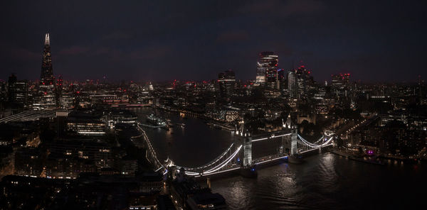 Aerial view to the illuminated tower bridge and skyline of london, uk