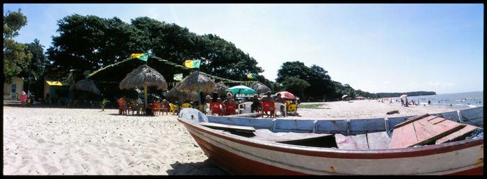 Panoramic view of people on beach against clear sky