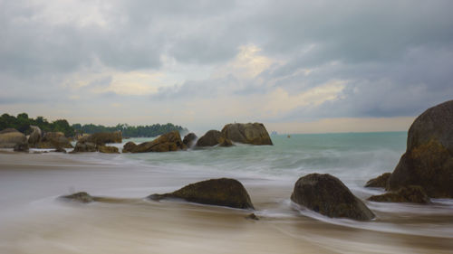 Rocks on beach against sky