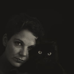 Portrait of woman with cat in darkroom