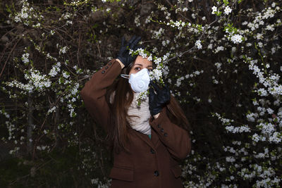 Woman standing by flowering plants