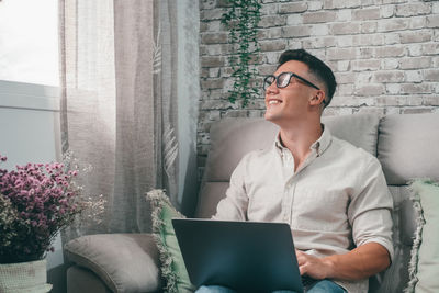 Young man using laptop while sitting at home