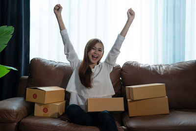 Young woman using laptop while sitting on sofa at home