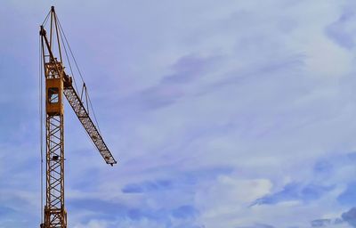 Low angle view of crane against sky
