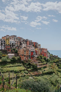 Houses in town by sea against sky