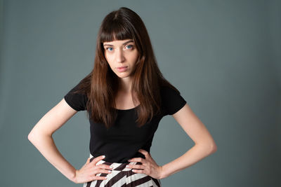 Portrait of beautiful young woman against gray background