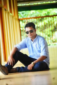 Portrait of man wearing sunglasses sitting on floor