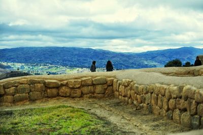 Men on landscape against sky
