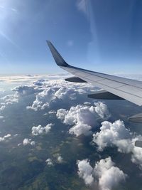 Airplane flying over clouds against blue sky