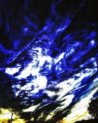 Low angle view of trees against blue sky