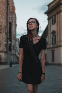Young woman wearing sunglasses standing on street