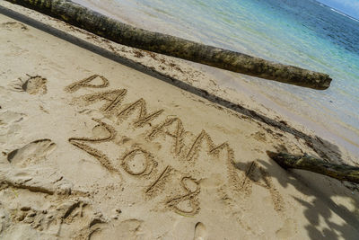 High angle view of text on sand at beach