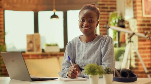 Portrait of young woman using mobile phone in cafe