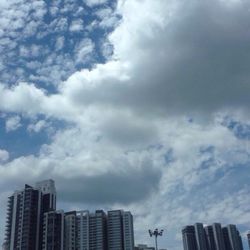 Low angle view of modern building against cloudy sky